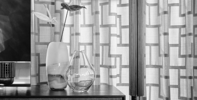 Vorhang mit muster und schöner Vase davor, schwarz weiss Foto